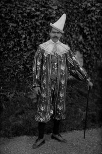 Un homme posant en costume de clown, à l