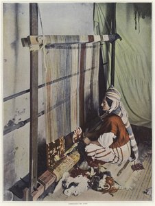 Une femme tissant une tapisserie sur un métier en Tunisie