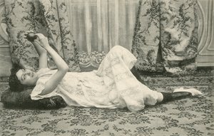 Fille, allongée sur le sol, tenant une balle au-dessus de sa tête - French Photographer
