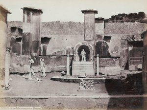 Vue partielle du jardin surélevé de la Maison de Marcus Lucretius à Pompéi, décoré de statues en marbre et de hermès. Au centre, une fontaine avec une niche. En arrière-plan, des fragments de peintures murales - Giorgio Sommer