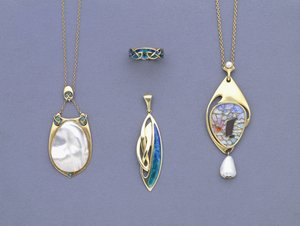 Un groupe de pendentifs en métal jaune et émail de Liberty & Co et une bague conçue par Archibald Knox - Giovanni Bigatti