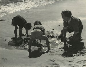 Trois enfants jouant avec du sable à la plage