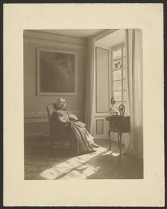 [Intérieur avec une femme assise en costume]