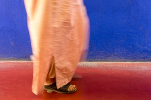 Passant devant un mur bleu au Jardin Majorelle à Marrakech, Maroc, 2014 (photo)