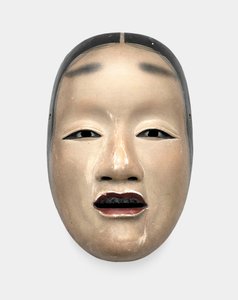 Un masque en bois avec fond gofun, peint avec sumi pour les cheveux, les yeux et les dents et rouge pour les lèvres