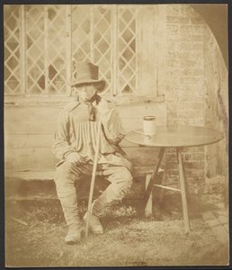[Homme assis à une table]
