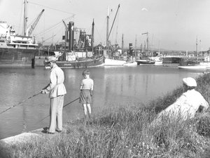 Un homme et un garçon pêchant dans Glasson Dock alors qu