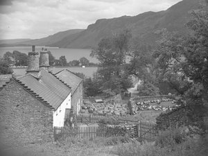 Bâtiments agricoles avec moutons dans la cour de ferme et Ullswater en arrière-plan