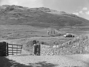 Vue de la route passant par le col de Hard Knott, deux personnes debout près d