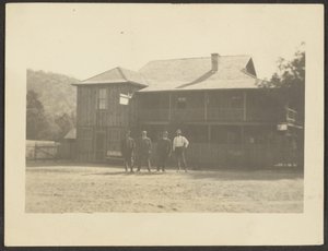 [Quatre hommes devant un bâtiment en bois]