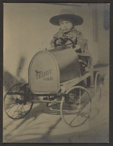 [Petit garçon assis dans une voiture en peluche]