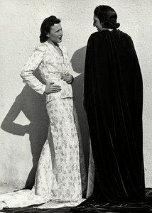 Deux mannequins présentent des créations de la maison de couture italienne "Dragoni". Un mannequin porte une tenue en tissu damassé composée d