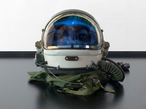 Alpha Omega, 2016 (verre, écran LCD, lecteur multimédia, réplique de crâne, casque spatial, bois) - Mat Collishaw