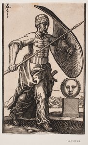 Soldat marchant vers la droite; sur le bras gauche un bouclier courbe, dans la main droite une lance; à droite un socle avec une tête sphérique vue de face; au loin derrière la tête une ville au bord de l