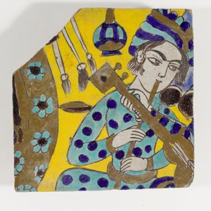Carreau de poterie Safavide de Perse de la fin du XVIIe siècle représentant un homme jouant de la flûte avec un turban