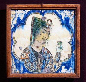 Carreau en céramique représentant une jeune femme tenant un vase, civilisation persane