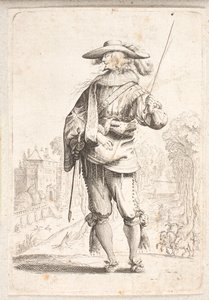 Soldat debout vu de face mais avec la tête en profil gauche. Tient un bâton dans la main gauche