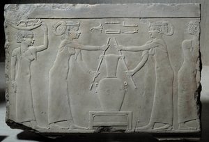 Antiquité égyptienne : bas-relief en calcaire représentant des femmes pressant des fleurs de lys pour extraire l