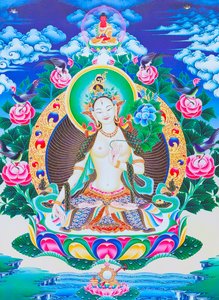 Image représentant Tara blanche, la mère divine aux sept yeux assise sur un lotus avec sa main droite en position varada mudra symbolisant la générosité