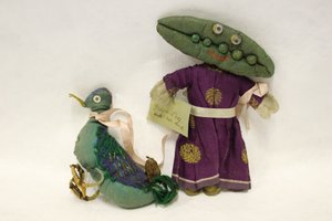 Poupée de chiffon Miss Green Peas, tête en forme de cosse de pois, menant son canard en laisse avec un ruban de satin rose