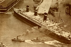 Photographie aérienne du Leviathan remorqué par de petits remorqueurs dans son dock à New York, vers 1930