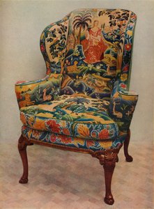 Un fauteuil rembourré avec ailes, cadre en noyer sculpté et couverture originale en broderie de soie, 17e siècle