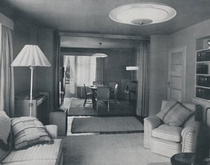 Salle à manger et salon, séparés uniquement par de lourds rideaux dans un tissage moderne attrayant