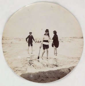 Deux filles et un garçon pataugeant dans la mer