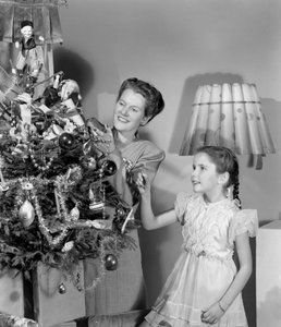 Femme et fille décorant un arbre de Noël, vers 1948 - Unbekannt