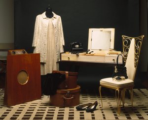 Mode et mobilier des années 1920 (Années folles) : radio anglaise Murphy 146, mobilier de salle de bain en ébène makassar et parchemin Dominique, siège en cuir blanc et fer forgé, téléphone de table Monophone électrique inc États-Unis