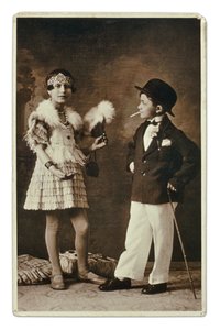 Deux enfants habillés en adultes selon la mode des années 1920, la petite fille porte une tenue pour le Charleston, et lui en costume, chapeau melon et cigarette. Photographie