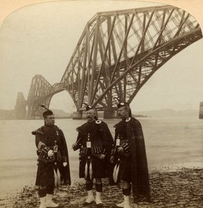 Hommes en costume écossais devant le pont du Forth, Écosse - Underwood and Underwood