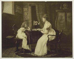 Femme et enfant jouant aux dominos à table - Unknown