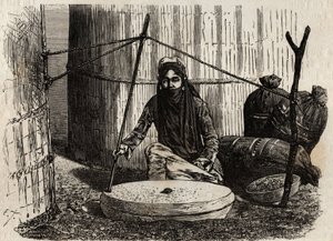 Femme turcomane utilisant la meule à grains, activant un ingénieux système de manivelle, la pierre supérieure tourne et en frottant cette pierre sur l