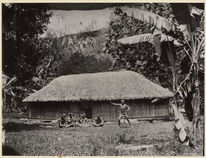 [Homme posé devant la cabane]