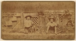 [Deux garçons assis par terre avec un chien]