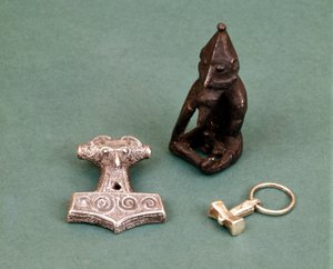 Amulettes des divinités vikings : au premier plan deux petits marteaux en argent symbolisant le dieu Thor. La statuette représente Freyr, dieu de la fertilité. Musée historique de Stockholm, Suède