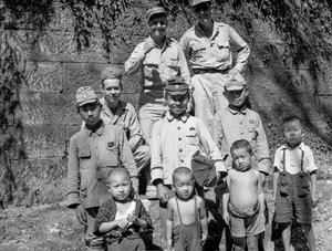 Soldats américains avec une famille japonaise posant ensemble après la reddition japonaise