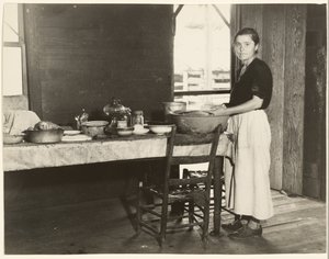 [Elizabeth Tengle à la table de cuisine]/[Paralee Ricketts travaillant dans la cuisine]