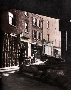 Paniers de fruits empilés contre des maisons au Borough Market, Londres, 1926-1927