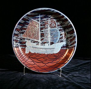 Plat avec lustre argenté, avec un galion naviguant sur une mer rouge en lustre