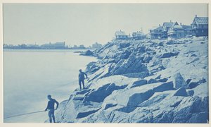 Deux hommes pêchant depuis des rochers dans une station balnéaire