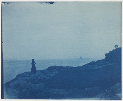 Femme regardant une goélette depuis un promontoire rocheux - American Photographer