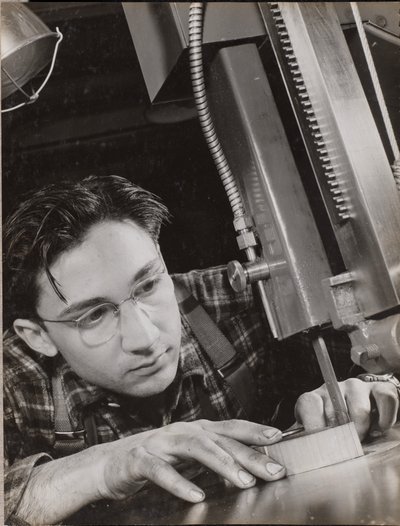 [Un homme portant des lunettes travaille intensément avec un dossier industriel]. - Arnold Eagle