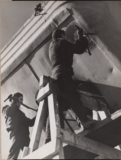 [Deux hommes travaillent sur le dessous d