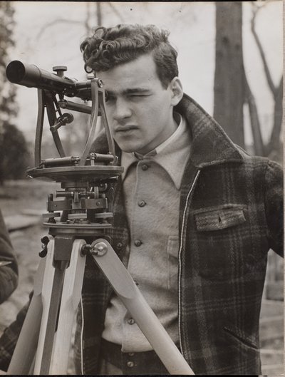 [Un jeune homme regarde à travers un outil d