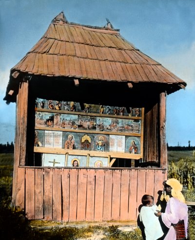 Roumanie, Bucovine, mère avec enfant devant une petite chapelle avec des images des Saints, date de l