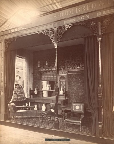Exposition de James Shoolbred & Co. -- Bâtiment Principal, scène de salon comprenant un buffet et un miroir avec des vases dessus et devant, des chaises, une table et un canapé. Sur le sol, un tapis et les murs sont couverts de papier peint floral - Centennial Photographic Co.