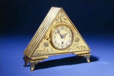 Une horloge de table triangulaire en laiton avec décoration florale gravée - Dagobert (attr. to) Peche