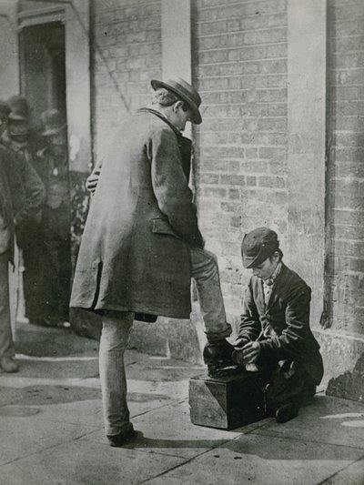 Un jeune cireur de chaussures cirant les chaussures d
